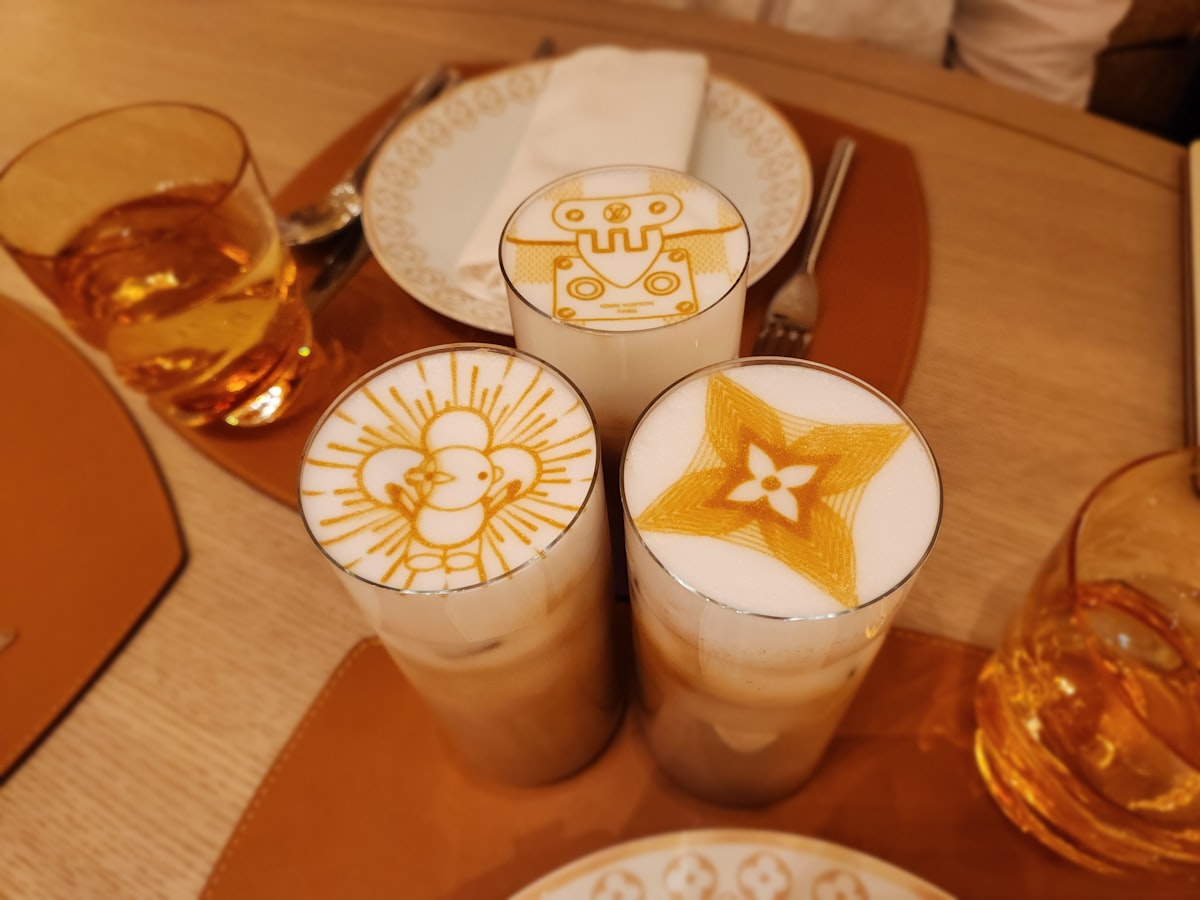 580° Coffee Roasting Company – Three lattes with intricate latte art designs on a table