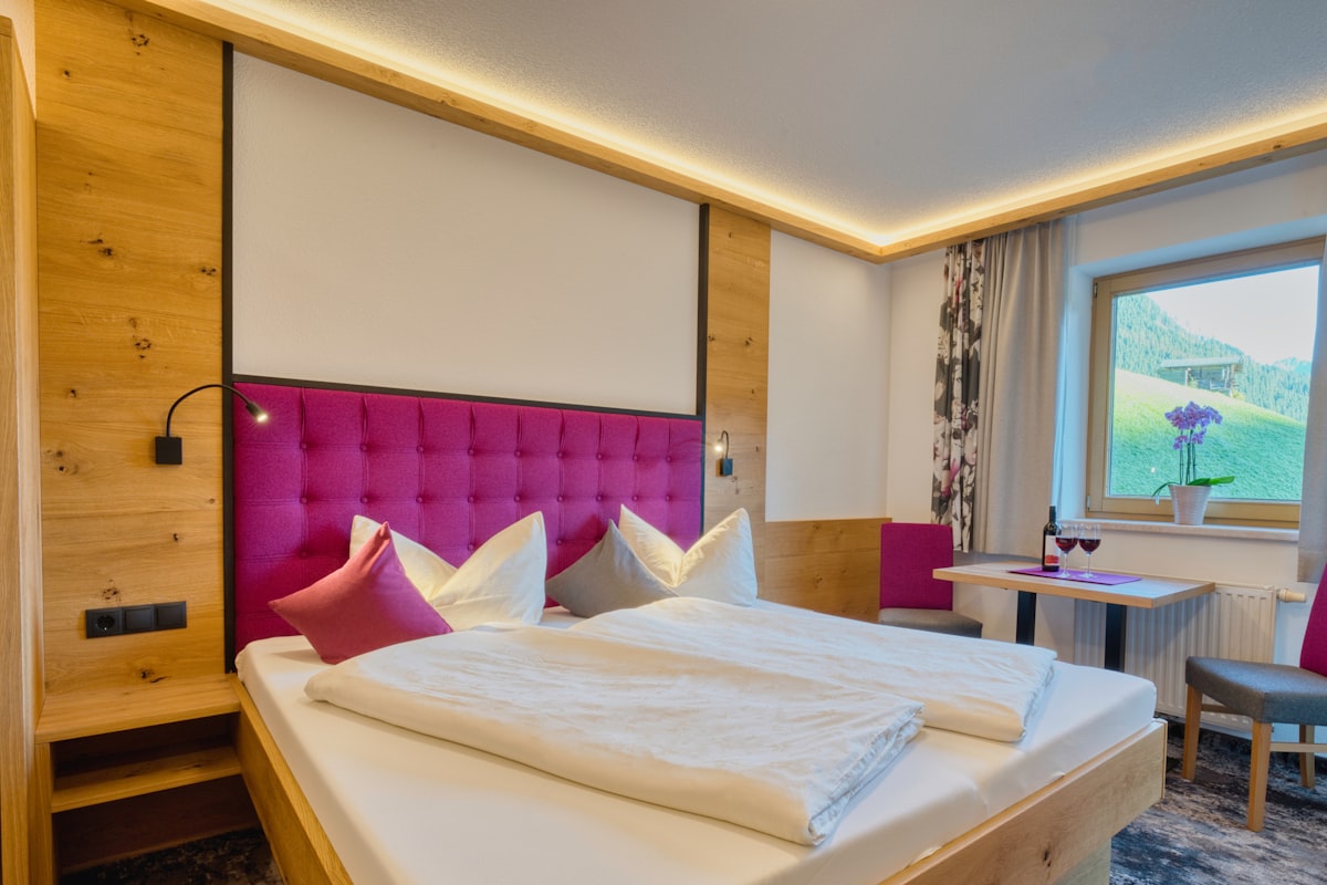 Nala Individuellhotel – A cozy hotel room with a large bed and window