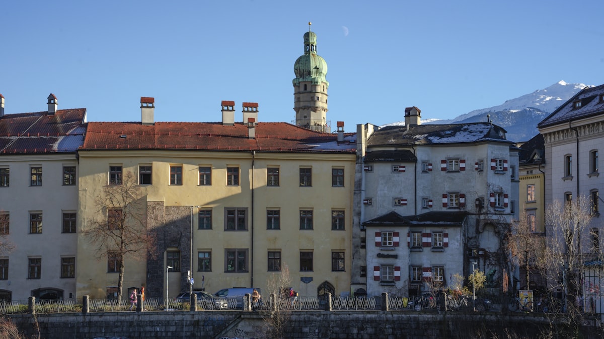 Schloss Ambras – Historic european buildings with a green dome against snowy mountains