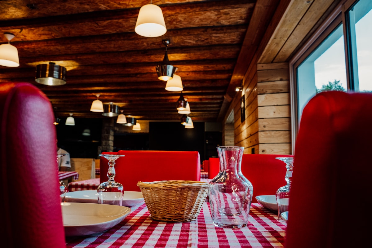 Wilder Mann – A table with a checkered table cloth and red chairs