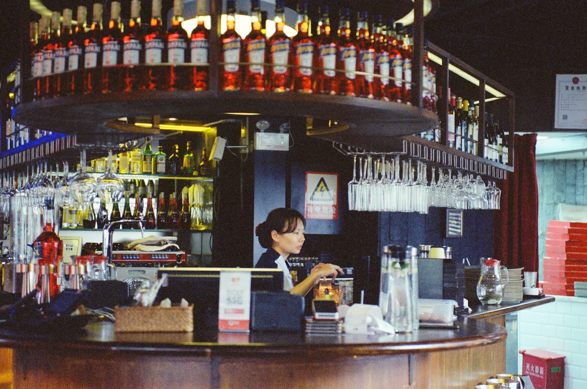 Yama Cocktailbar – Bartender working behind a bar with bottles